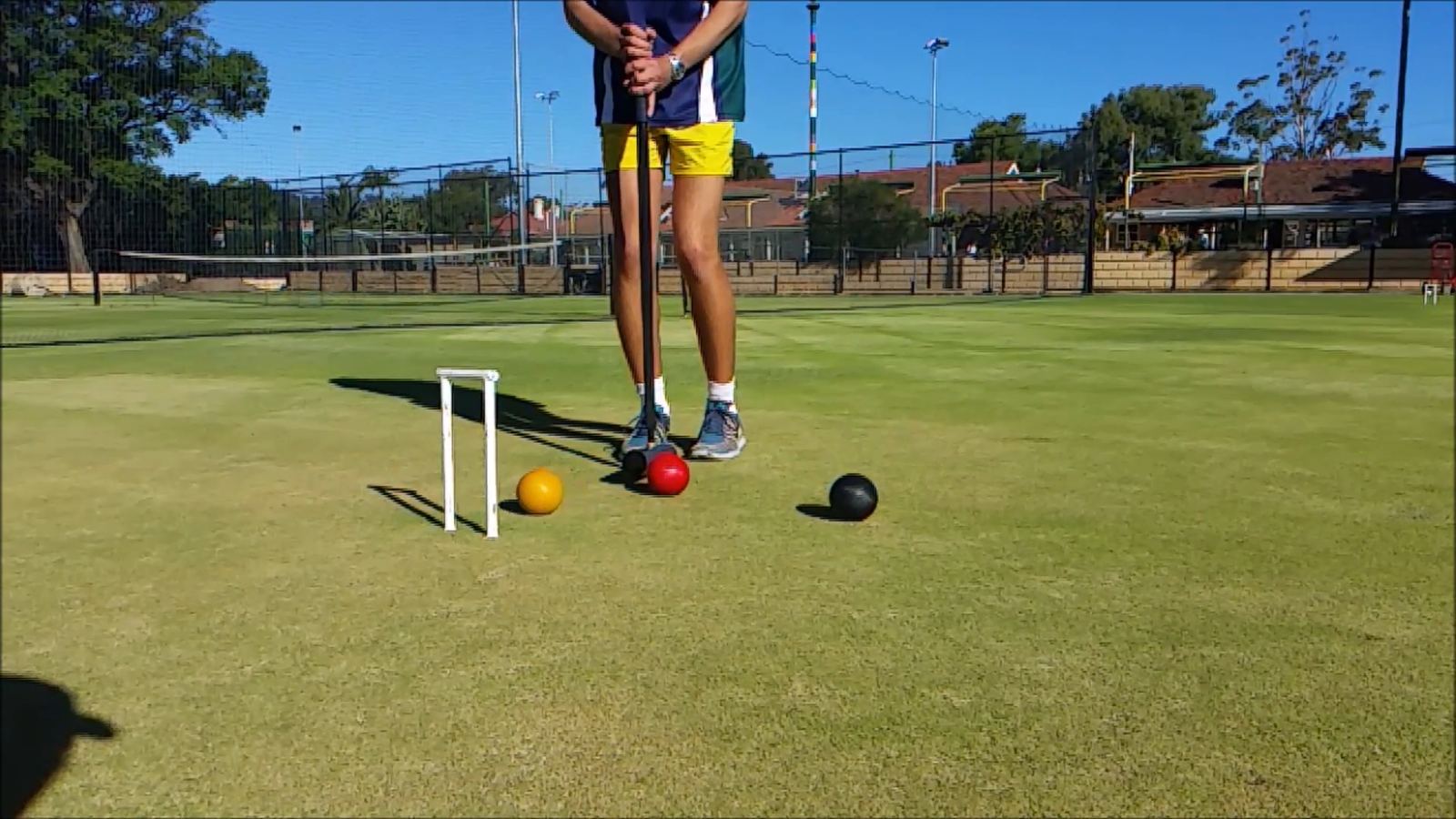 A player standing over three balls beside a hoop